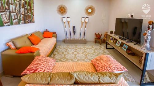 sala de estar con sofá y TV de pantalla plana en Pousada Recanto Sol Nascente, luxo e proximidade com a natureza en Rio Formoso