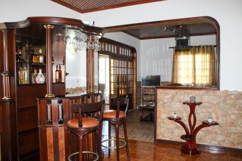a bar with stools and a mirror in a room at Vila Almeida in Ponta Delgada