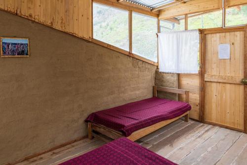 Habitación con banco púrpura en una casa de madera en Vrindavan Perú Jardín Ecológico, en Matucana