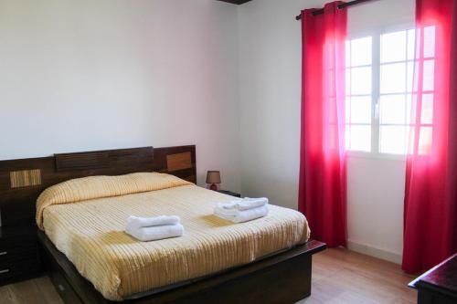 een slaapkamer met een bed met twee handdoeken erop bij Vila Almeida in Ponta Delgada