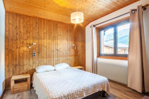 une chambre avec un lit et une fenêtre dans l'établissement Efanle 2, à Morzine