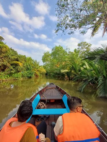 two men riding in a boat down the river at AUTHENTIC HOMESTAY in Can Tho