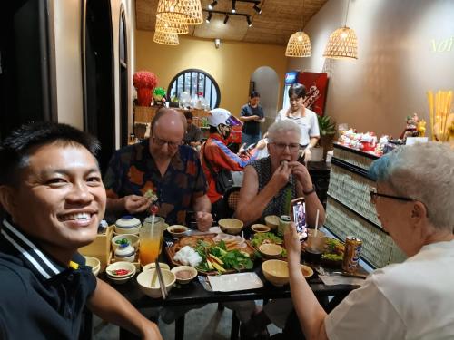 a group of people sitting around a table eating food at AUTHENTIC HOMESTAY in Can Tho