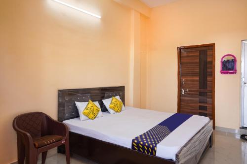 a bedroom with a bed and a chair at SPOT ON Hotel Pragya 5 in Raipur