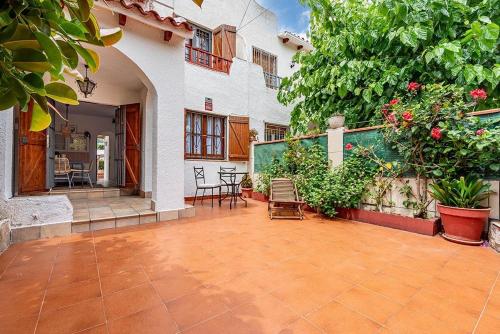 une cour d'une maison avec des chaises et des plantes dans l'établissement Preciosa casa al lado del mar, à Creixell