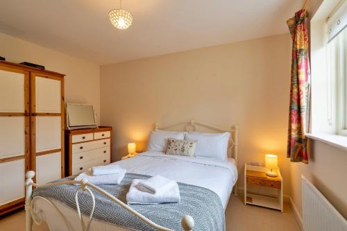 a bedroom with a bed with towels on it at Finest Retreats - Hardie Close in Tetbury