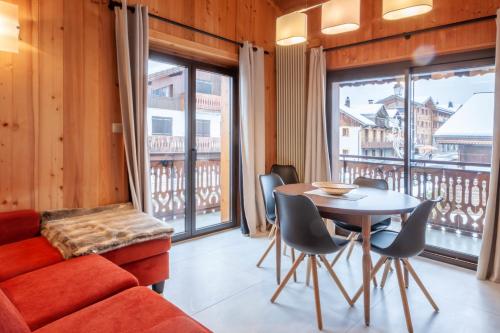 un salon avec un canapé et une table avec des chaises dans l'établissement Efanle 2, à Morzine