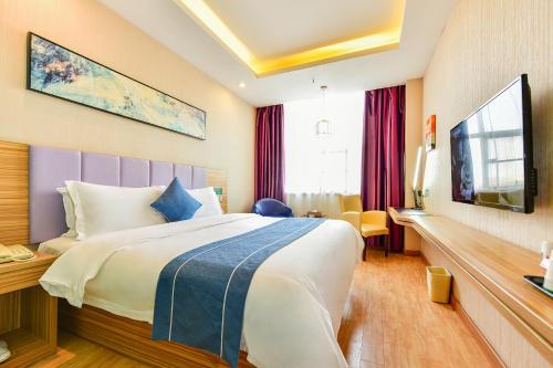 a hotel room with a bed and a tv at Shanshui Trends Hotel Pazhou International Exhibition Center Branch in Guangzhou