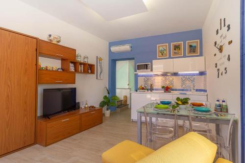 un salon avec une table et une télévision dans l'établissement Vivaldo Suite - Accademia, à Sorrente