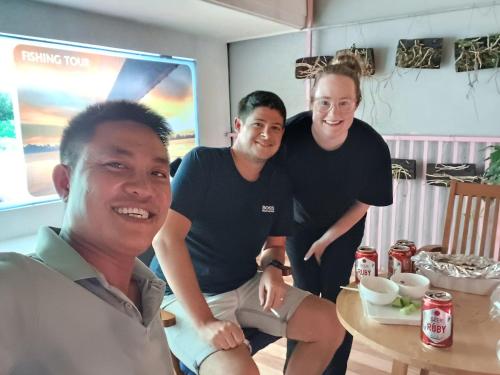 a group of three men standing around a table at AUTHENTIC HOMESTAY in Can Tho