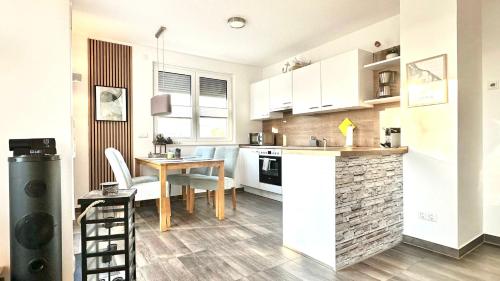 eine Küche und ein Esszimmer mit einem Tisch und Stühlen in der Unterkunft Apartment "Sonnendeck" - Haffresidenz in Zirchow