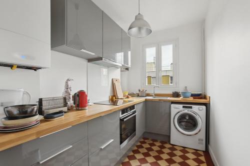 une cuisine avec un lave-linge et un lave-linge dans l'établissement L'Atypique - Charmant Duplex au coeur du 20eme, à Paris