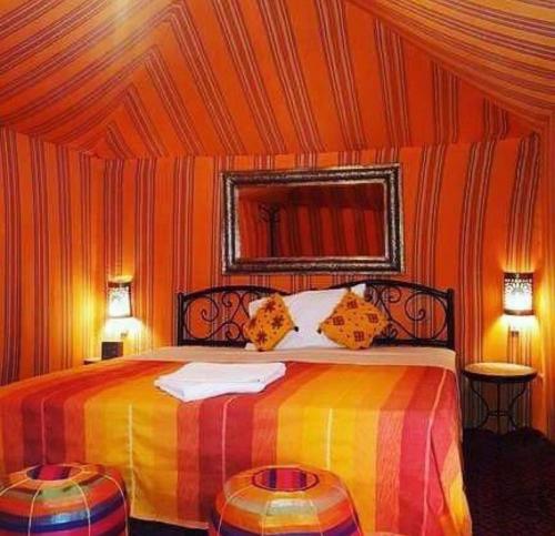 a bedroom with a colorful bed in a tent at Desert Berber Camp in Merzouga