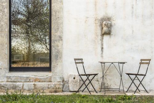 two chairs and a table in front of a building at Casa Balat in Noto