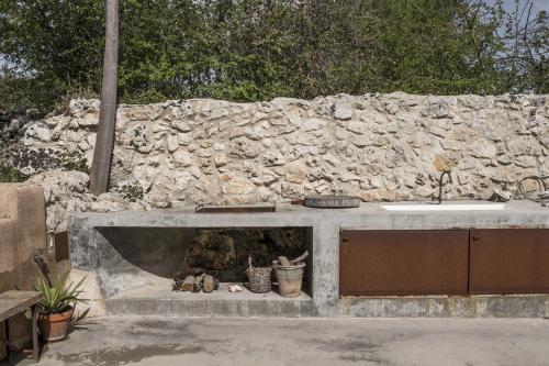a stone wall with a sink and a fireplace at Casa Balat in Noto