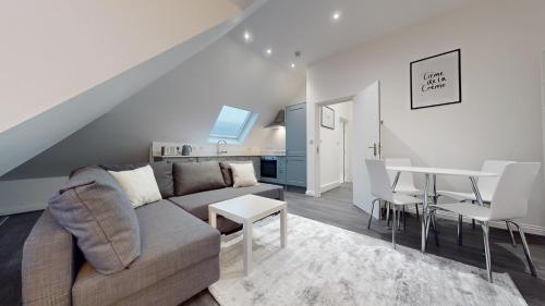 een woonkamer met een bank en een tafel bij LONDON STAY Flats in Londen