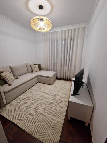 a living room with a couch and a television at Wild Blue By SVL in Ponta Delgada