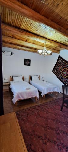 a room with two beds and a ceiling at Boutique Hotel Breshim in Bukhara