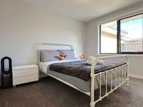 a bedroom with a bed with a teddy bear on it at New Kingston Trampoline House in Kingston