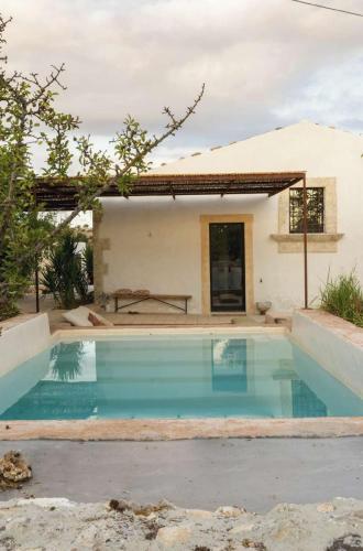a swimming pool in front of a house at Casa Balat in Noto