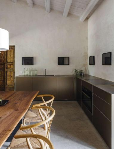 a kitchen with a long wooden table and chairs at Casa Balat in Noto