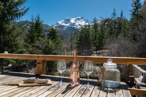- une table avec des verres à vin et une bouteille sur la terrasse dans l'établissement Le Mas des Vigne - Jardin - Barbecue - Brasero, à Uvernet