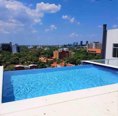 une piscine sur le toit d'un bâtiment dans l'établissement Amplio y Super Equipado Studio en Villa Morra, à Asuncion