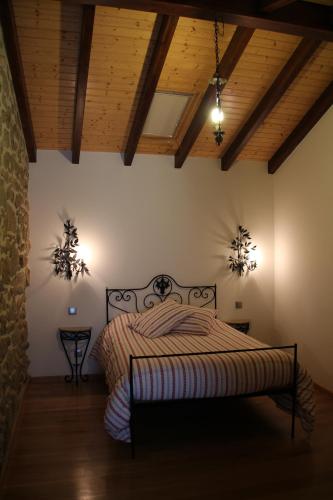 a bedroom with a bed in a room with wooden ceilings at Casa Maria da Assunção in Vila Nova de Cerveira