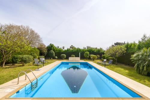 a swimming pool in a yard with chairs and trees at Villa Anassa Private Pool Near Beach in Paphos