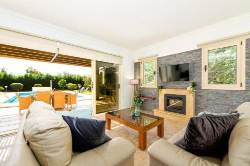 ein Wohnzimmer mit Couch und Kamin in der Unterkunft Villa Anassa Privat Pool Near Beach in Klorakas