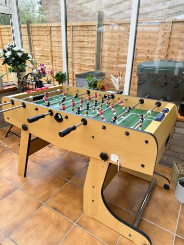 a wooden foosball table in a garden at 5 bedroom detached house sleeps 13 spacious Parking 5 mins driving to Bicester Village in Bicester