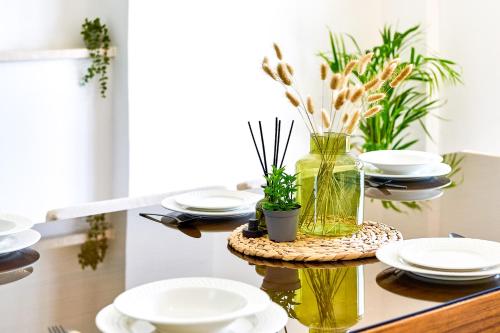 a table with white plates and a vase with flowers at Villa Anassa Private Pool Near Beach in Paphos