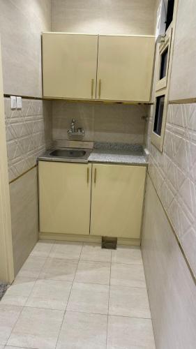 a small kitchen with a sink and a tiled floor at دانه القحطاني للوحدات السكنية in Tabuk