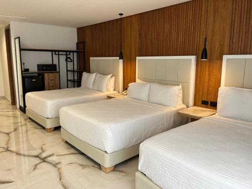 a hotel room with two beds with white sheets at Hotels 111 in San Andrés