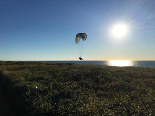 ヒアツハルスにあるB&B by the Sea Hirtshalsの凧を海上で飛ばしている人