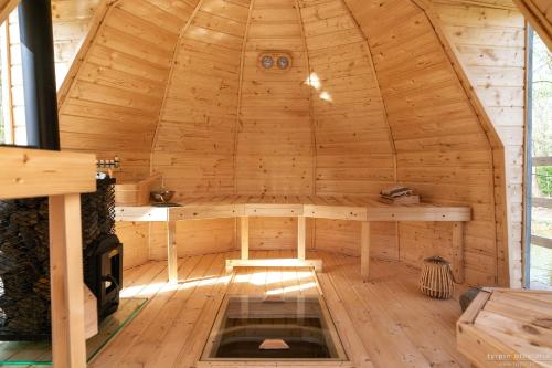 a wooden sauna with a table in the middle at Bunkier House in Niedźwiada
