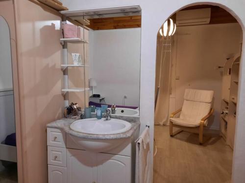 ein Badezimmer mit einem Waschbecken, einer Dusche und einem Stuhl in der Unterkunft Villa climatisée piscine in Montpellier