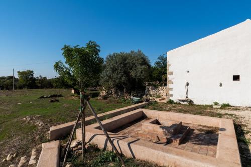 a garden with a pit in the ground next to a building at Casa Balat in Noto