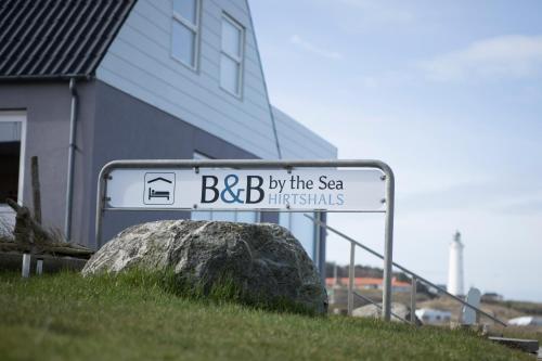 un letrero de la calle para bbb junto al mar y una roca en B&B by the Sea Hirtshals, en Hirtshals