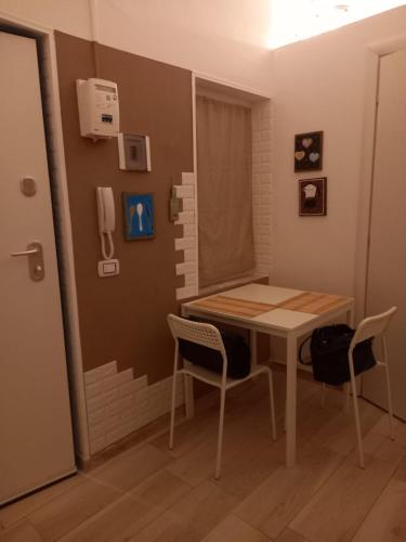 Zimmer mit einem Tisch, 2 Stühlen und einem Telefon in der Unterkunft PANTA RHEI in Taranto