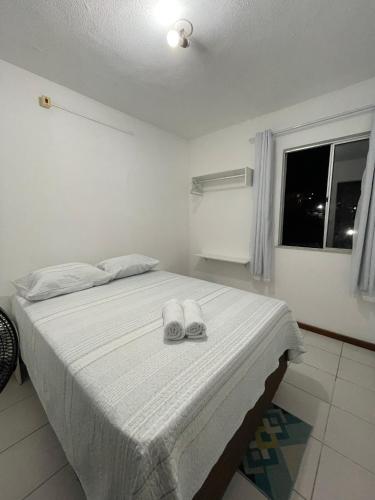a bedroom with a bed with two slippers on it at Apartamento aconchegante 2 in Jequié