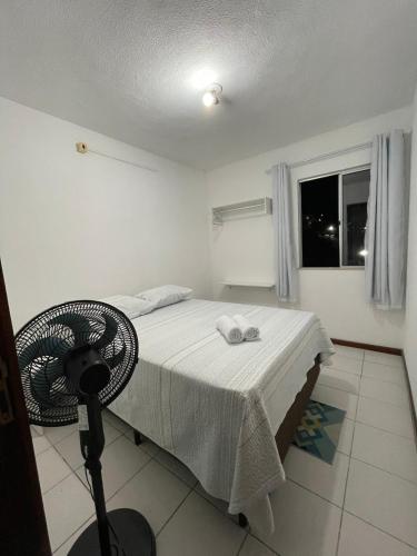 a bedroom with a bed with a fan and a window at Apartamento aconchegante 2 in Jequié