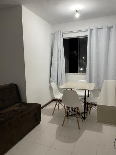 - un salon avec une table, des chaises et un canapé dans l'établissement Apartamento aconchegante 2, à Jequié