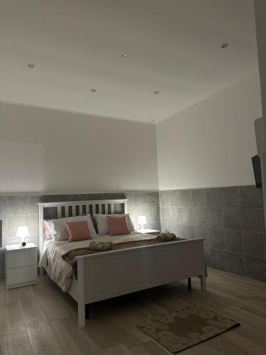 ein Schlafzimmer mit einem großen Bett mit rosa Kissen in der Unterkunft PANTA RHEI in Taranto