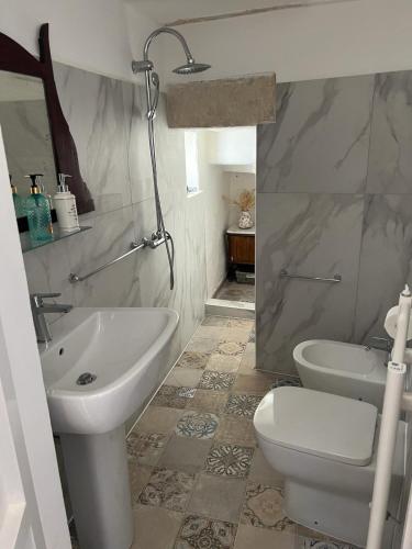 La salle de bains est pourvue d'un lavabo, de toilettes et d'un miroir. dans l'établissement Dimora Lucrezia - B, à Corigliano dʼOtranto