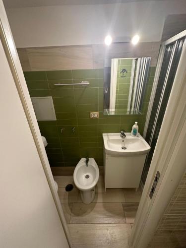 ein grünes Bad mit einem WC und einem Waschbecken in der Unterkunft PANTA RHEI in Taranto
