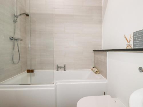 a white bathroom with a tub and a toilet at The Stables in Camelford