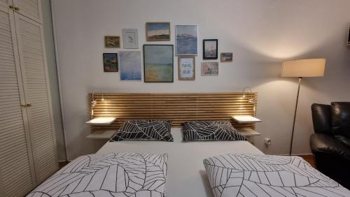 um quarto com uma cama e uma cadeira e quadros na parede em Apartments Peter em Ljubljana