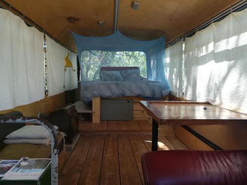 1 dormitorio con 1 cama y 1 mesa en una tienda de campaña en Bus-chambre à Chateaudouble en Châteaudouble