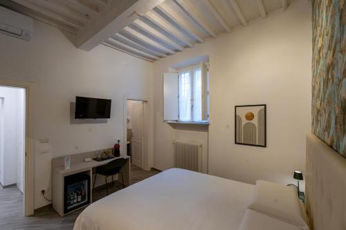 Dormitorio con cama, escritorio y TV en B&B Via Corsica 10 en Pisa